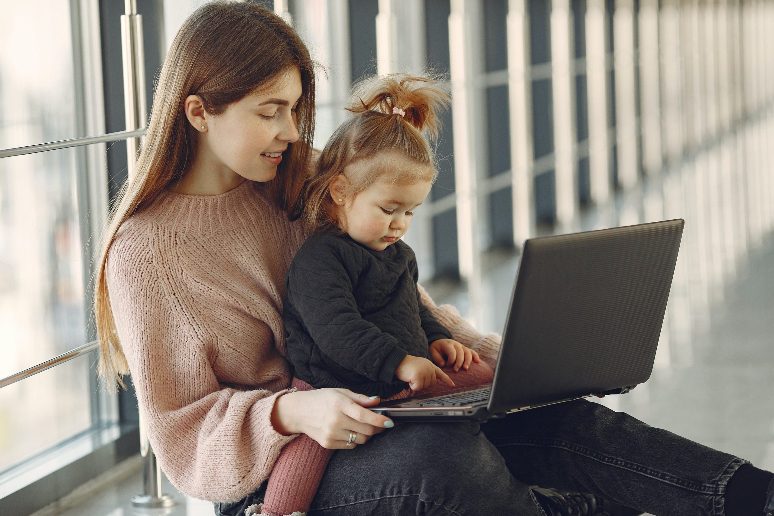 smiling-woman-with-daughter-using-laptop-4173206